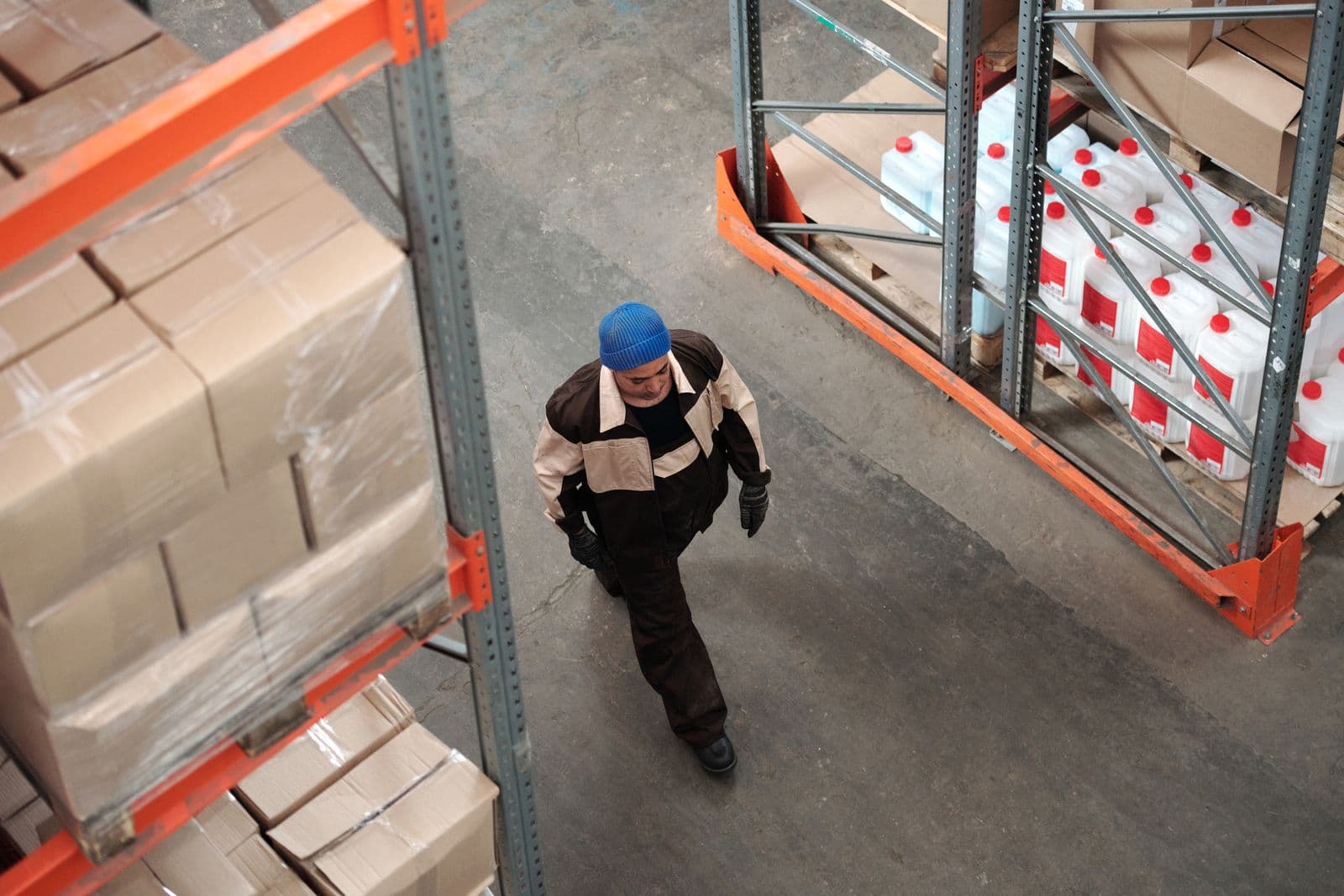 A worker moving through the aisles of a busy warehouse.